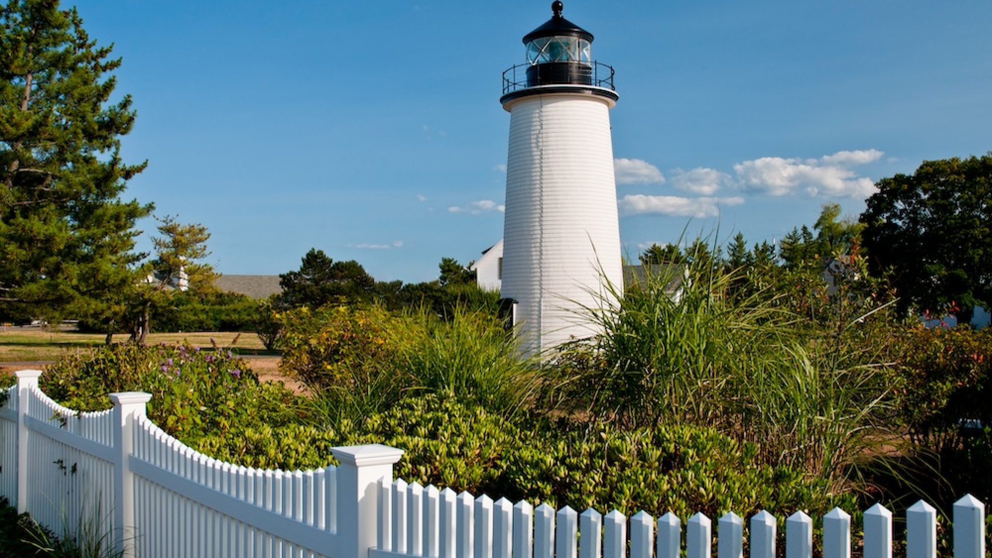 White Picket Fence by Newburyport Harbor Lighthouse In Massachusetts.