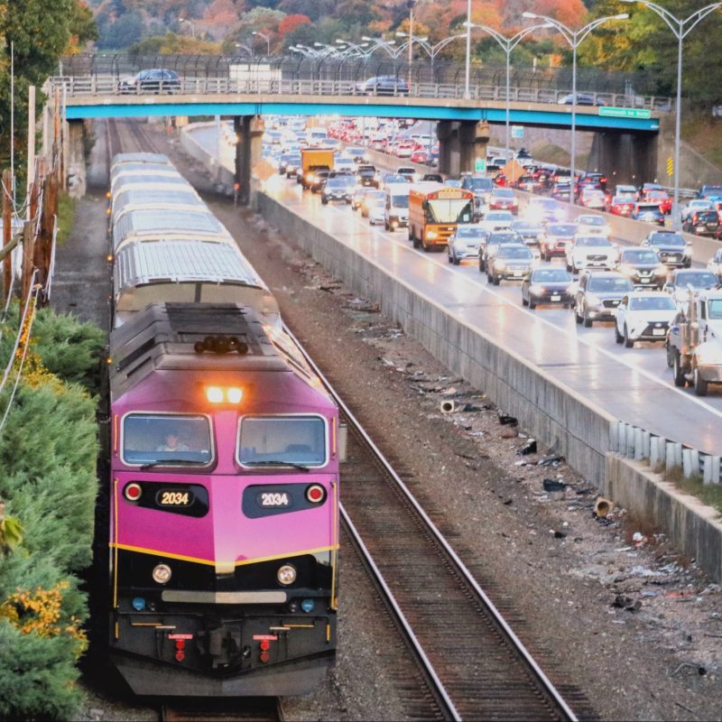 Commuter Rail train moving faster than highway traffic
