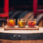 Three cocktail samples on a wooden board at Bully Boy Distillery