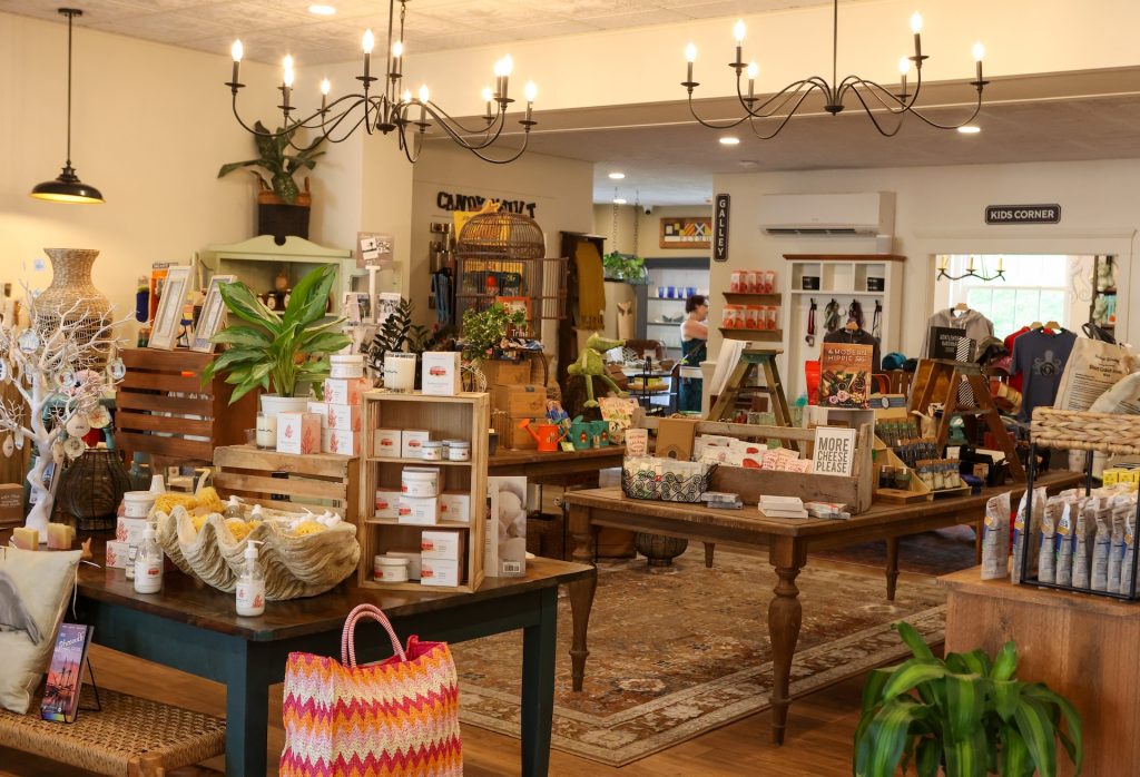 Interior of gift shop, showing locally made handcrafted candles, jewelry and bags for sale.