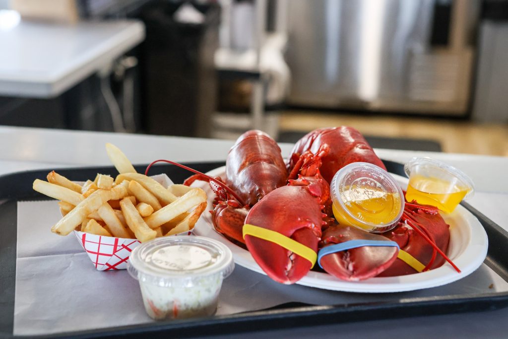 Fresh boiled lobster on a plate with french fries.