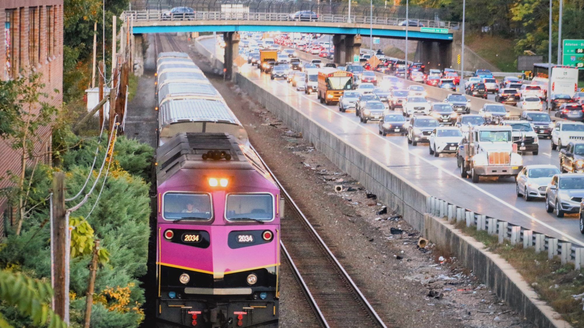Commuter Rail train passing traffic on the highway.