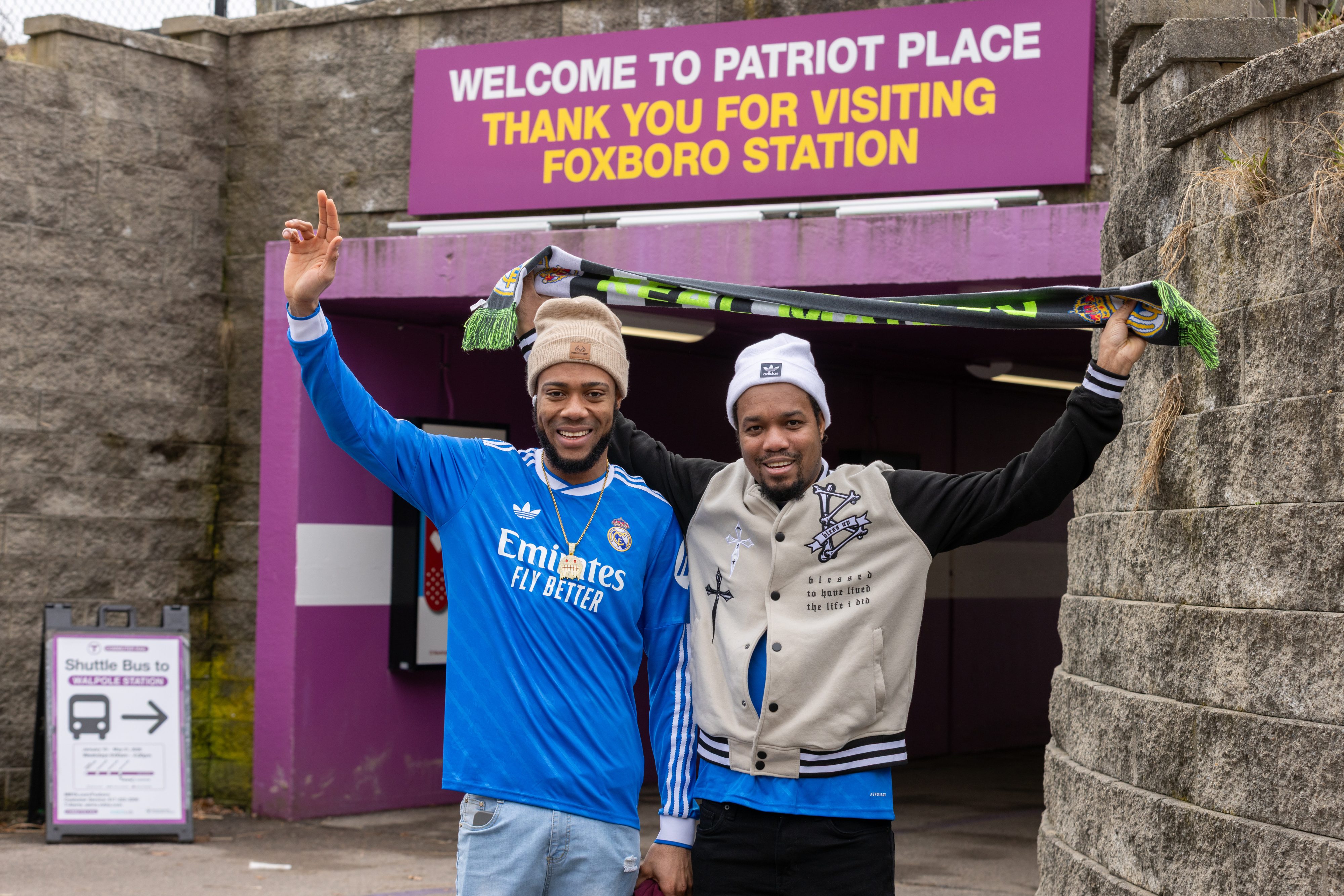 To friends posing outside of a Commuter Rail Station